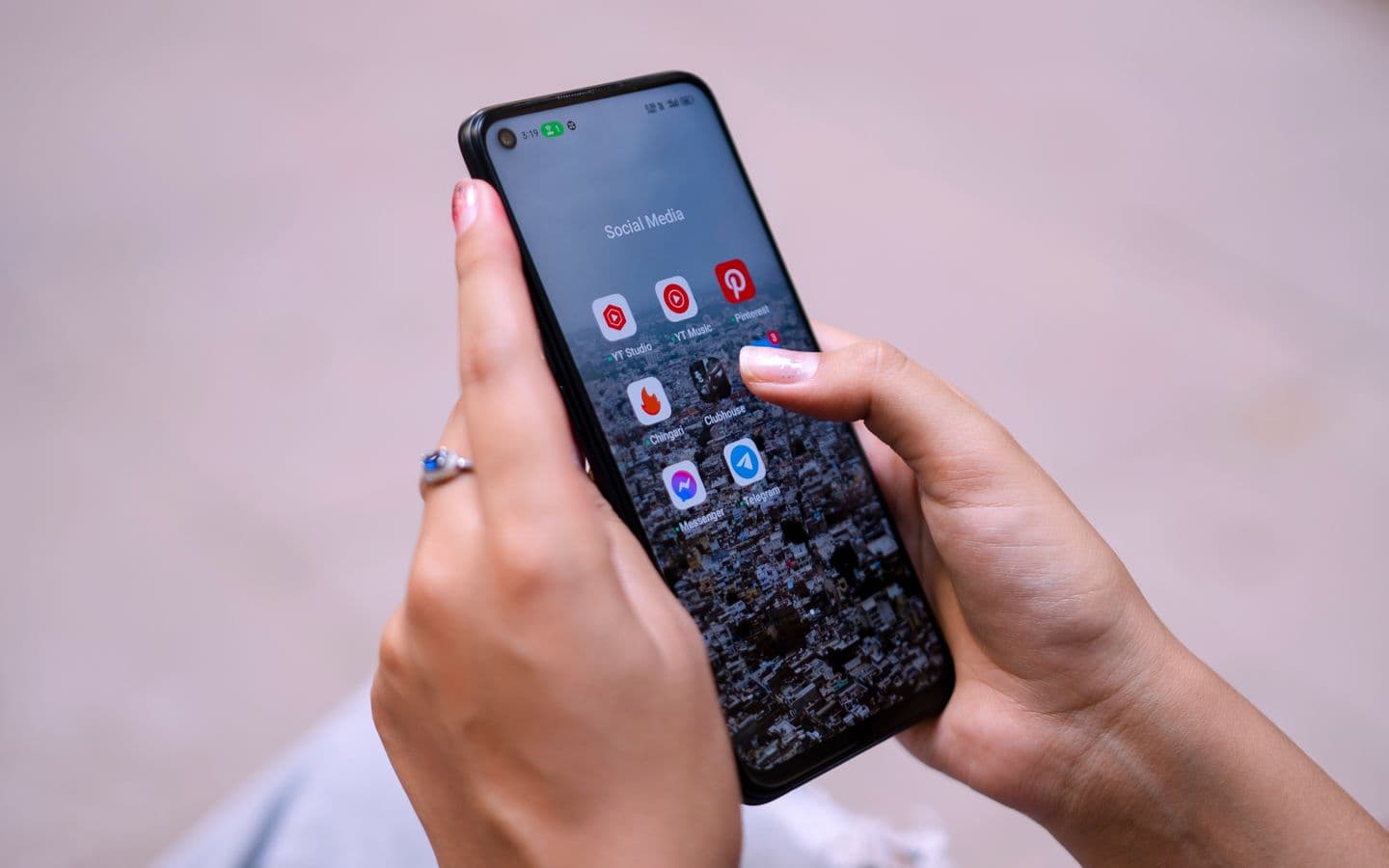 Nahaufnahme von Händen mit einem Smartphone, auf dem Apps sozialer Netzwerke zu sehen sind