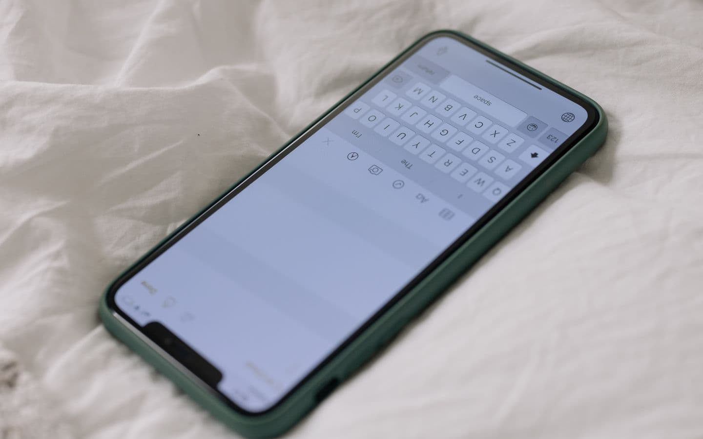Smartphone liegt auf einem weißen Leinen-Bettlaken