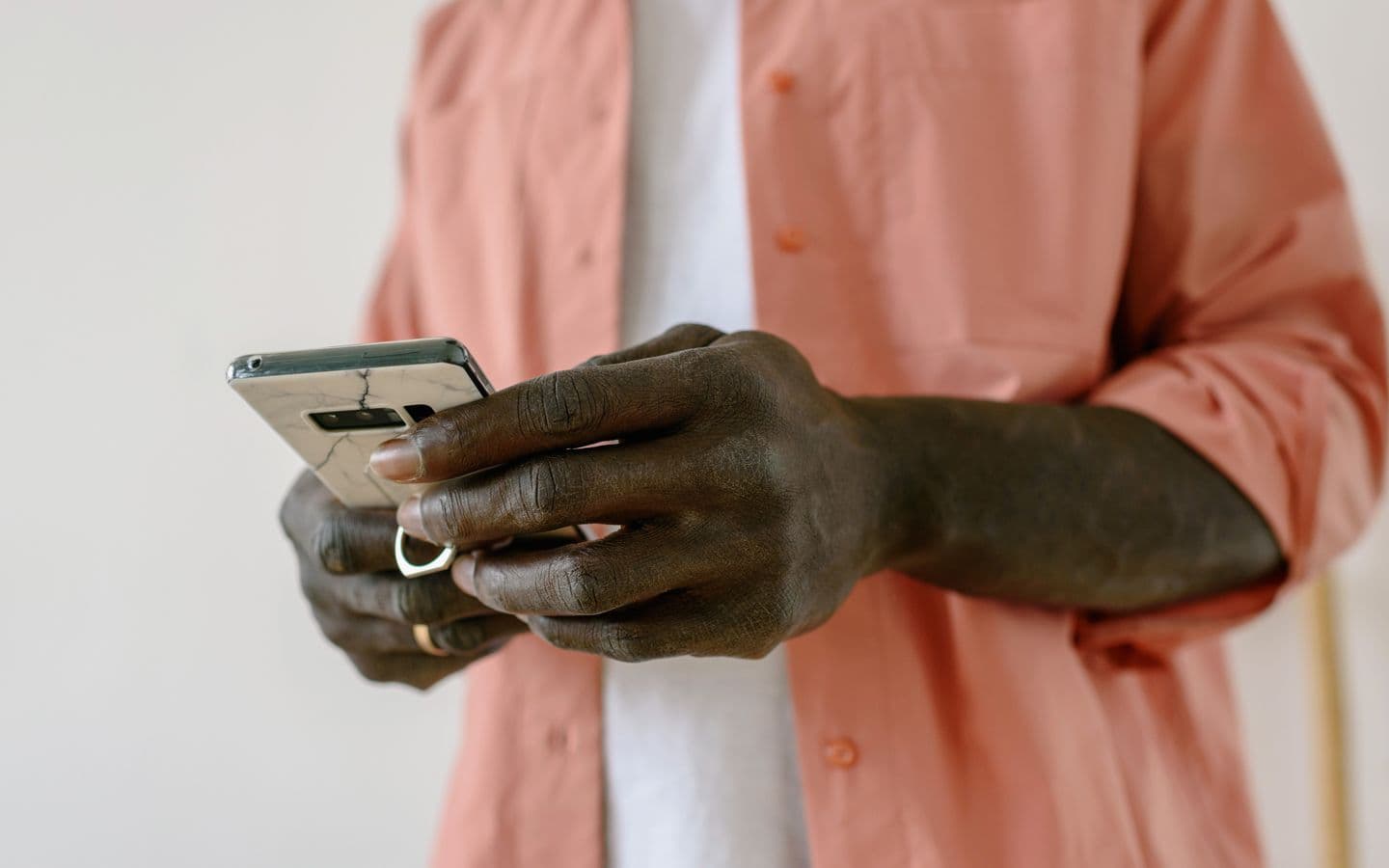 Nahaufnahme einer Person, die drinnen ein Smartphone bedient