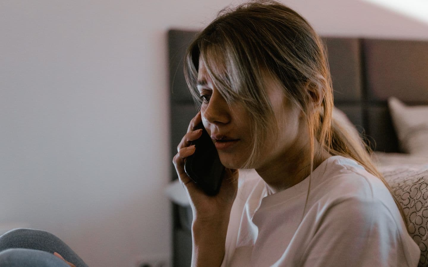 Besorgte Frau telefoniert in einem Innenraum
